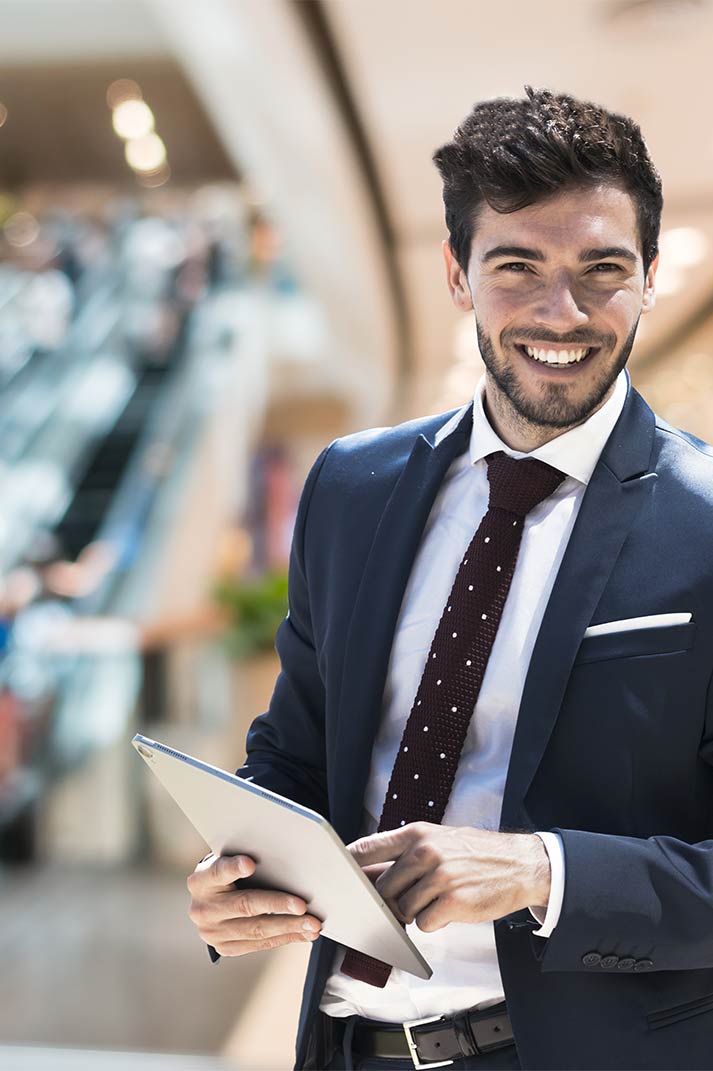 Animateur d'événement souriant et tablette à la main dans un centre commercial